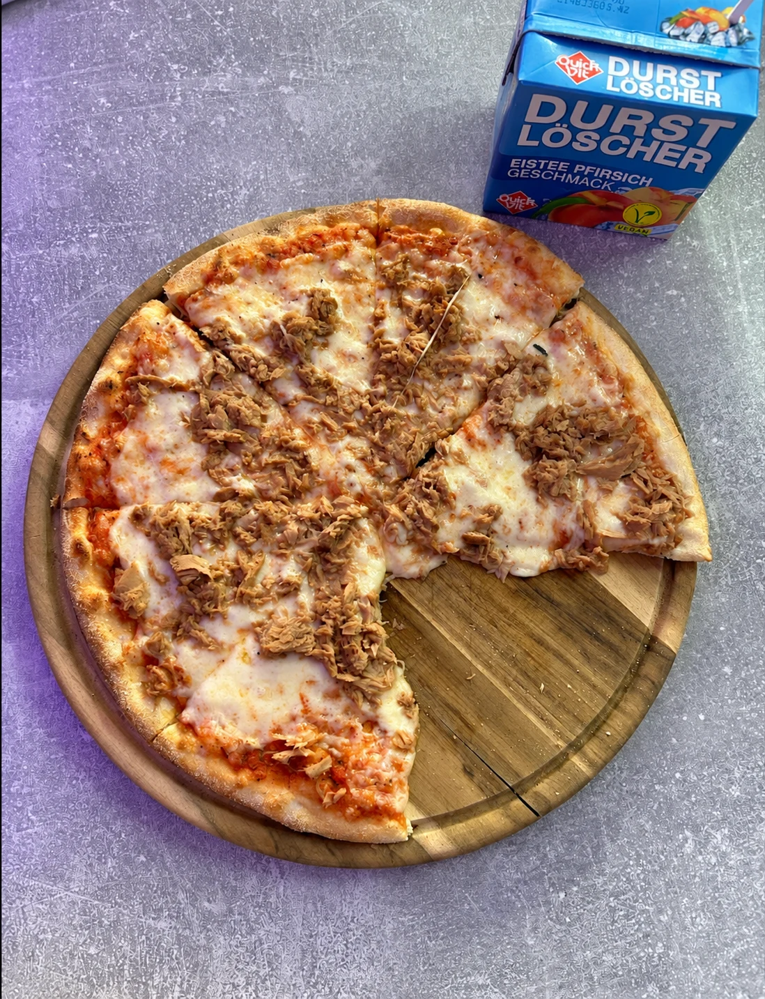 Pizza mit Drehspießfleisch auf einem Holzbrett